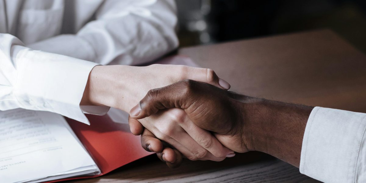 Professionals shaking hands, symbolizing a new partnership or deal in the investment sector.