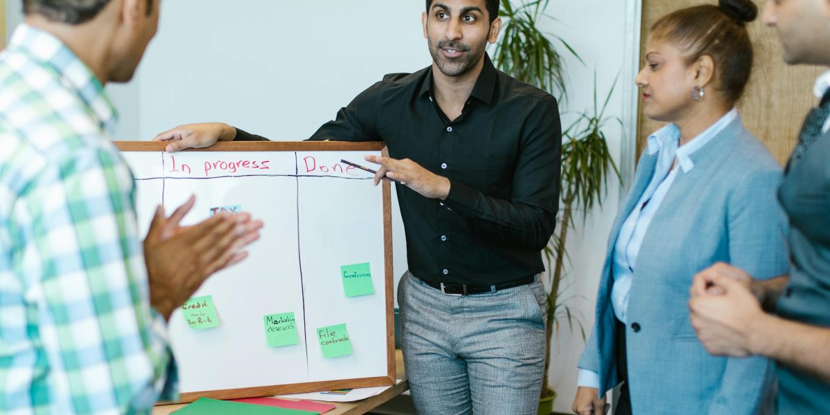 A diverse team collaboratively brainstorming on a whiteboard, aiming for clarity in definitions.