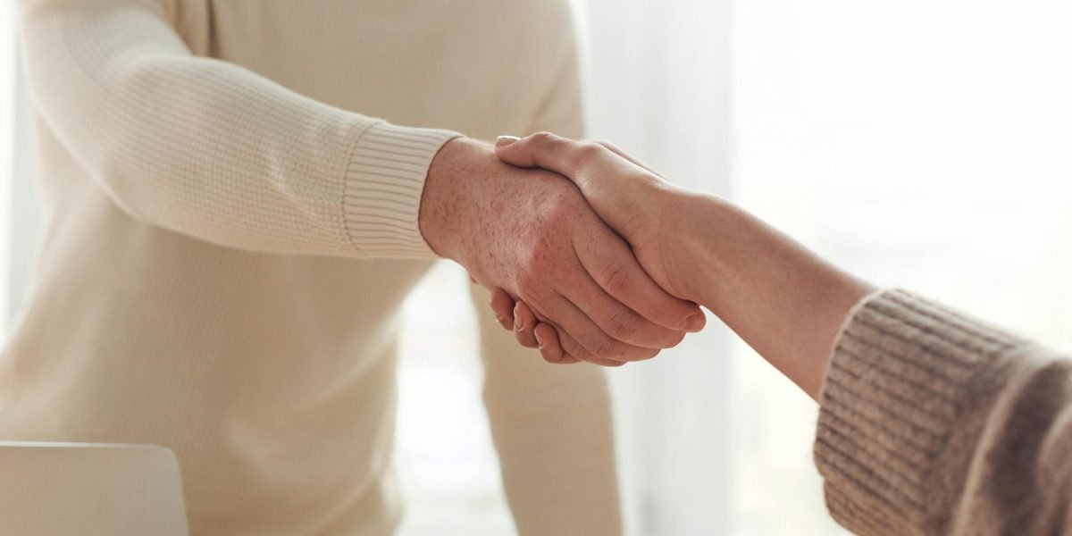 Two business partners shaking hands, signifying trust and a strong working relationship.
