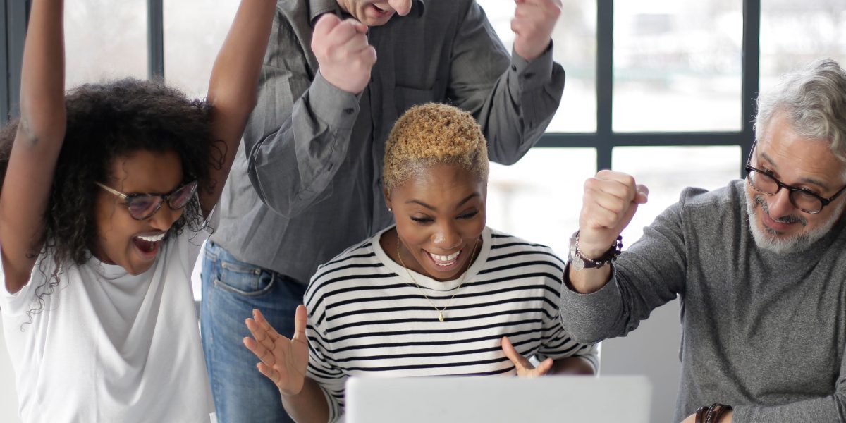 A team celebrating a significant breakthrough in a modern, collaborative environment.