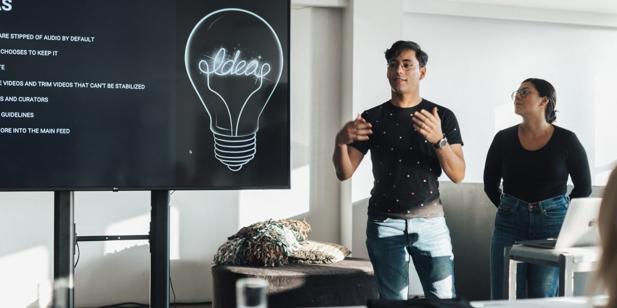 A startup team confidently presents their innovative business idea to a panel of potential investors during a demo day event.