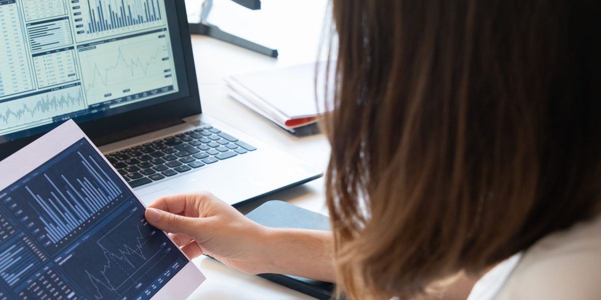 An individual thoughtfully reviewing numerous documents, symbolizing the challenge of sifting through vast information in investment.