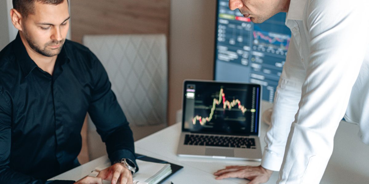 Professionals discussing investment strategies and market players in a collaborative setting.