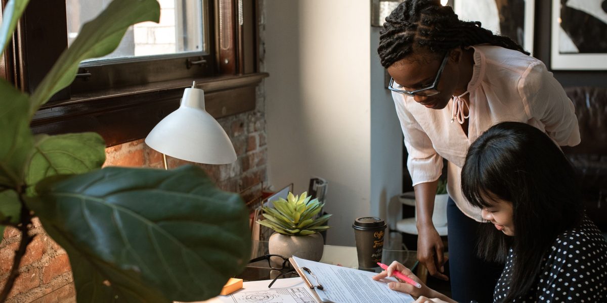 A mentor providing guidance and advice to a young entrepreneur on strategic approaches.