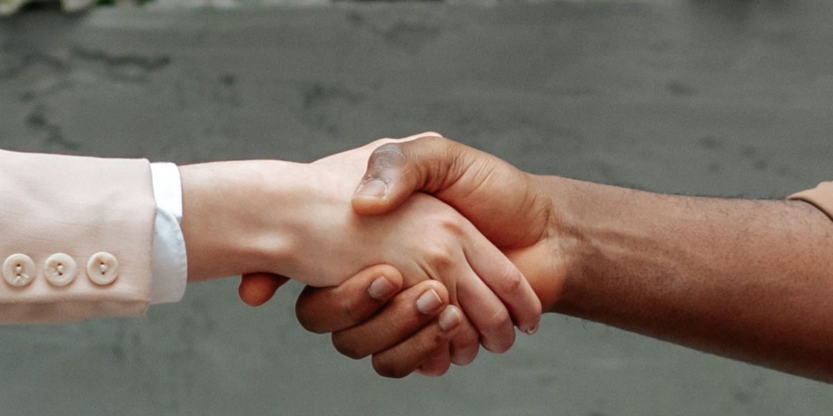 Professionals shaking hands, symbolizing a successful negotiation or agreement to attract new growth capital.