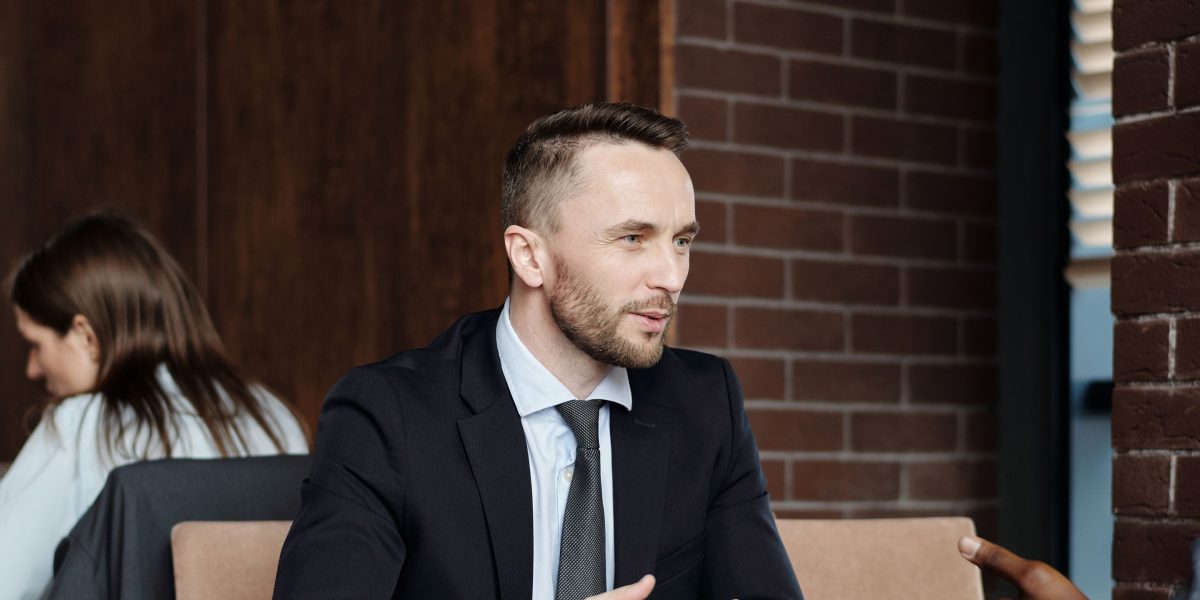 A group of professionals in a modern meeting space, engaged in a discussion about potential future opportunities and growth.