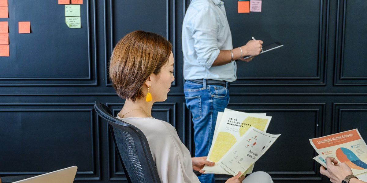 A collaborative team discusses strategies and prepares essential documentation for an upcoming investor meeting.