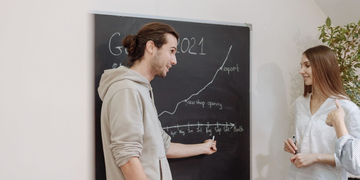 A diverse team collaborating around a whiteboard, actively discussing plans for business expansion and future growth.