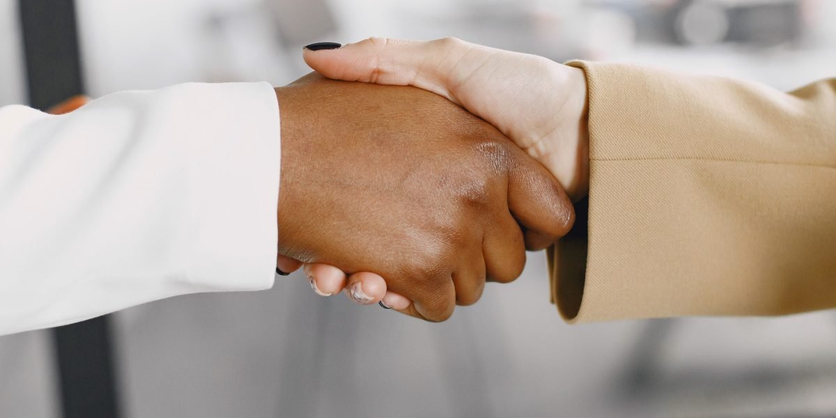 Two professionals shaking hands, symbolizing a successful partnership or agreement after a business meeting.
