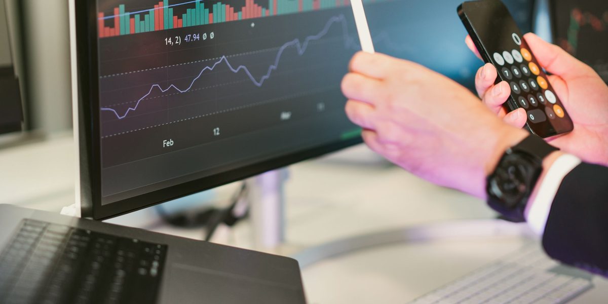 A professional examining financial charts and data to understand market trends and make informed investment decisions.