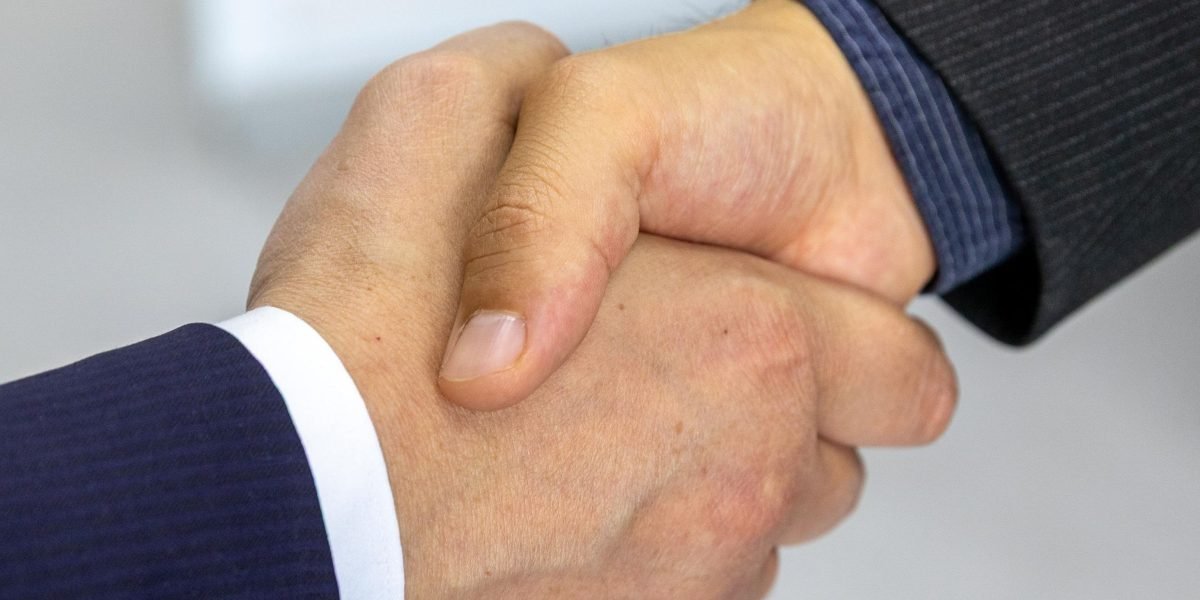Professionals shaking hands, symbolizing a successful deal closure and the beginning of a new partnership.