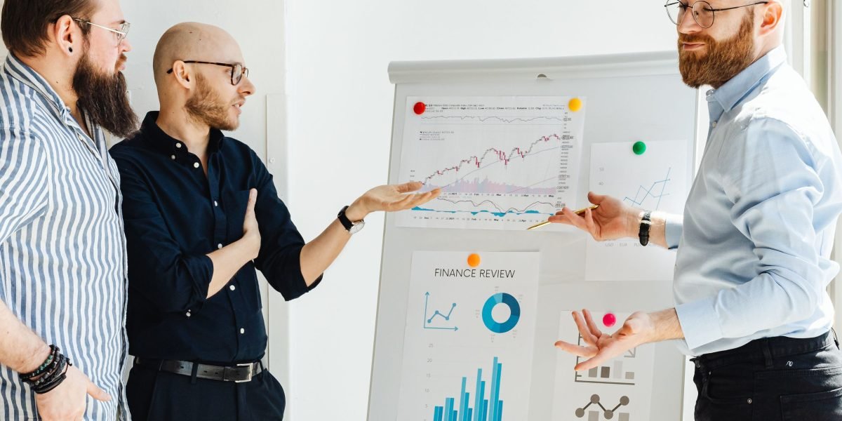 A team discusses strategy at a whiteboard, illustrating the ongoing management and planning required after securing excelerate funding.