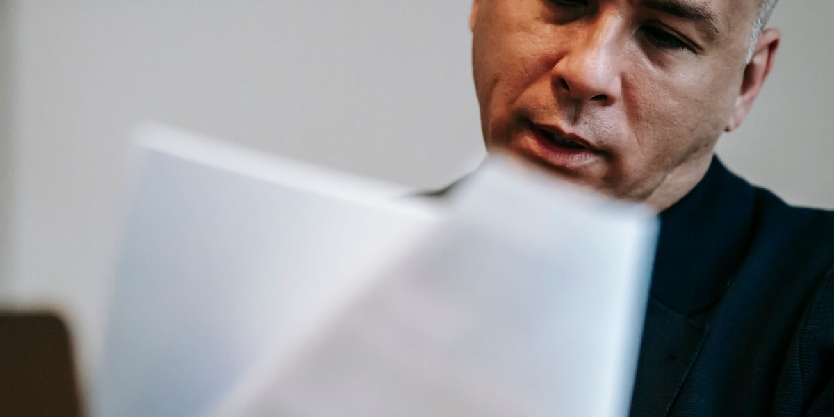 A dedicated entrepreneur meticulously reviewing grant application documents to ensure completeness and competitiveness.