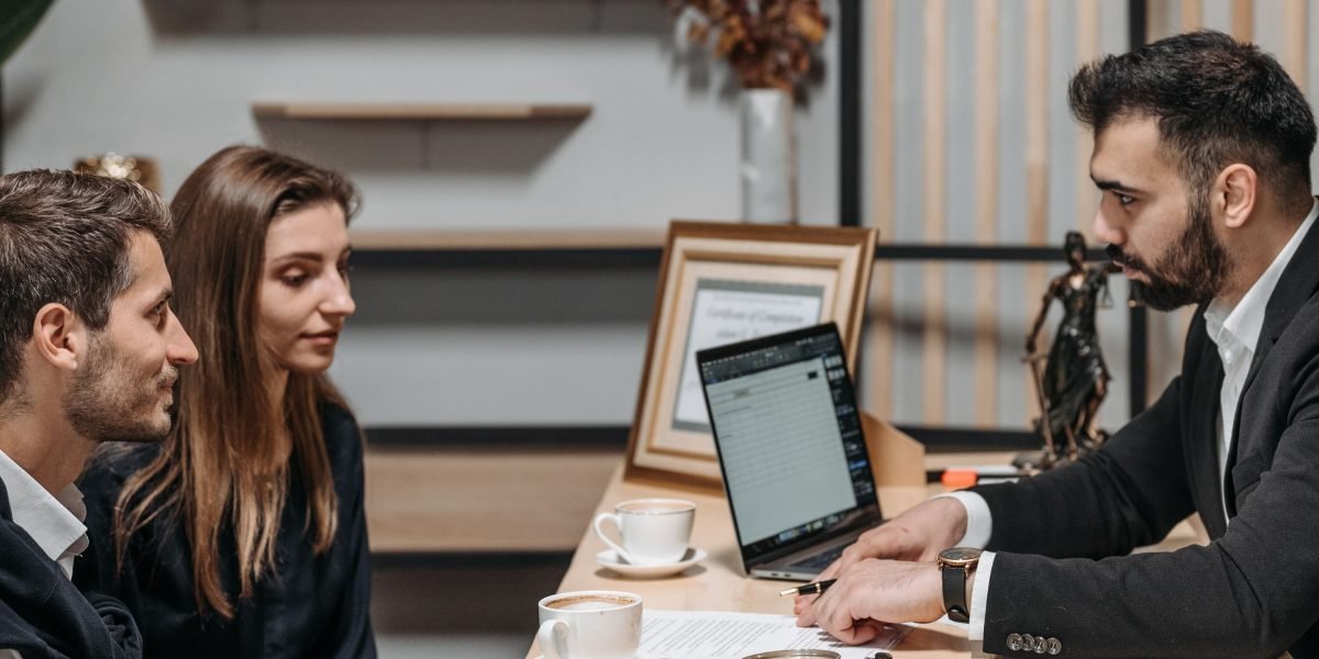 Financial professionals in a meeting with clients, demonstrating the collaborative nature of large-scale financial services.